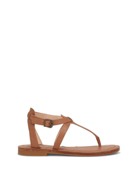 The FRYE Taylor Sandal in Tan features full grain leather, a T-strap design, adjustable ankle strap with buckle, and a thin rubber sole, shown against a plain white background.