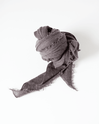 The Grisal Love Cashmere Scarf in Brown Top is loosely tied with fringed edges, displayed on a white background and one end extending outward.
