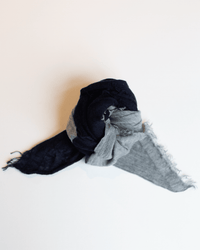 The Grisal Love Duo Mini in Navy & Hthr Grey features a cashmere color block design with twisted, knotted styling and frayed edges, shown against a plain white background.