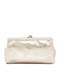 The Manuela Clutch in Platino by IL BISONTE features metallic gold leather, brass hardware, a kiss-lock clasp, and an embossed logo on the front, all handcrafted in Italy and shown against a white background.