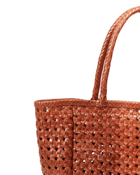 Close-up of the Annette Petit Cuir Bag in Picante by Maison N.H Paris, showing its woven basket-like texture and craftsmanship. Only the top portion of this handmade-in-India mini tote with two handles is visible against a white background.