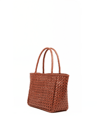 The Annette Petit Cuir Bag in Picante by Maison N.H Paris is a rectangular, two-handle tote handmade in India from brown woven buffalo leather, featuring a spacious open-top design and shown against a white background.