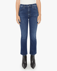 A person wearing Mother Lil Hustler Ankle in Heirloom jeans, a white top, and black pointed-toe ankle boots stands against a plain white background. The image is cropped at the shoulders.