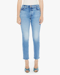 A person wears Mother’s The Tomcat Flood in Tasty Waves—high rise, straight leg jeans in light blue comfort stretch denim—with teal open-toed heels, standing against a plain white background, arms relaxed for a subtle vintage vibe.