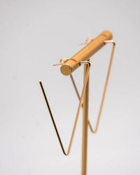 A minimalistic 14K Gold Fill earring stand displays the Nashelle Large Geo Hoops in 14k Gold Fill, shown against a plain, light grey background.