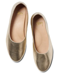 The beek.. Swiftlet in Gold features gold leather ballet flats with rounded toes, light tan insoles, and a memory foam footbed, shown from above on a white background.