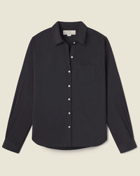 The Grace Classic Shirt in Black by Trovata Birds of Paradis is a long-sleeve, collared button-up with a chest pocket, made from 100% cotton and shown against a light beige background.