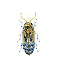 The Trovelore Florentinus Beetle Brooch Pin is a realistic, hand-embroidered accessory with blue, gold, white, and black threads and intricate beadwork. This handmade insect pin is shown on a plain white background.