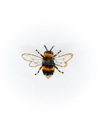 The Trovelore Humble Bee Brooch Pin, featuring black and yellow stripes with translucent wings, is displayed from above on a plain white background.