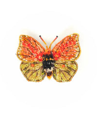 The Trovelore Maderensis Felder Butterfly Brooch Pin features orange, red, and green beaded wings with intricate embroidery and sequins. Displayed on a white background, it's a perfect choice for collectors of hand embroidered brooches.