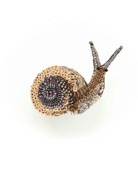 The Trovelore Melting Snail Brooch Pin is a hand-embroidered accessory from India, crafted with beads and sequins in beige, brown, gold, and purple to form the snail’s shell and body, displayed on a plain white background.