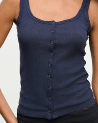 A person wears the Adelle Button Up Tank in Navy by Velvet by Graham & Spencer, standing against a plain light background with only the torso and upper arms visible.