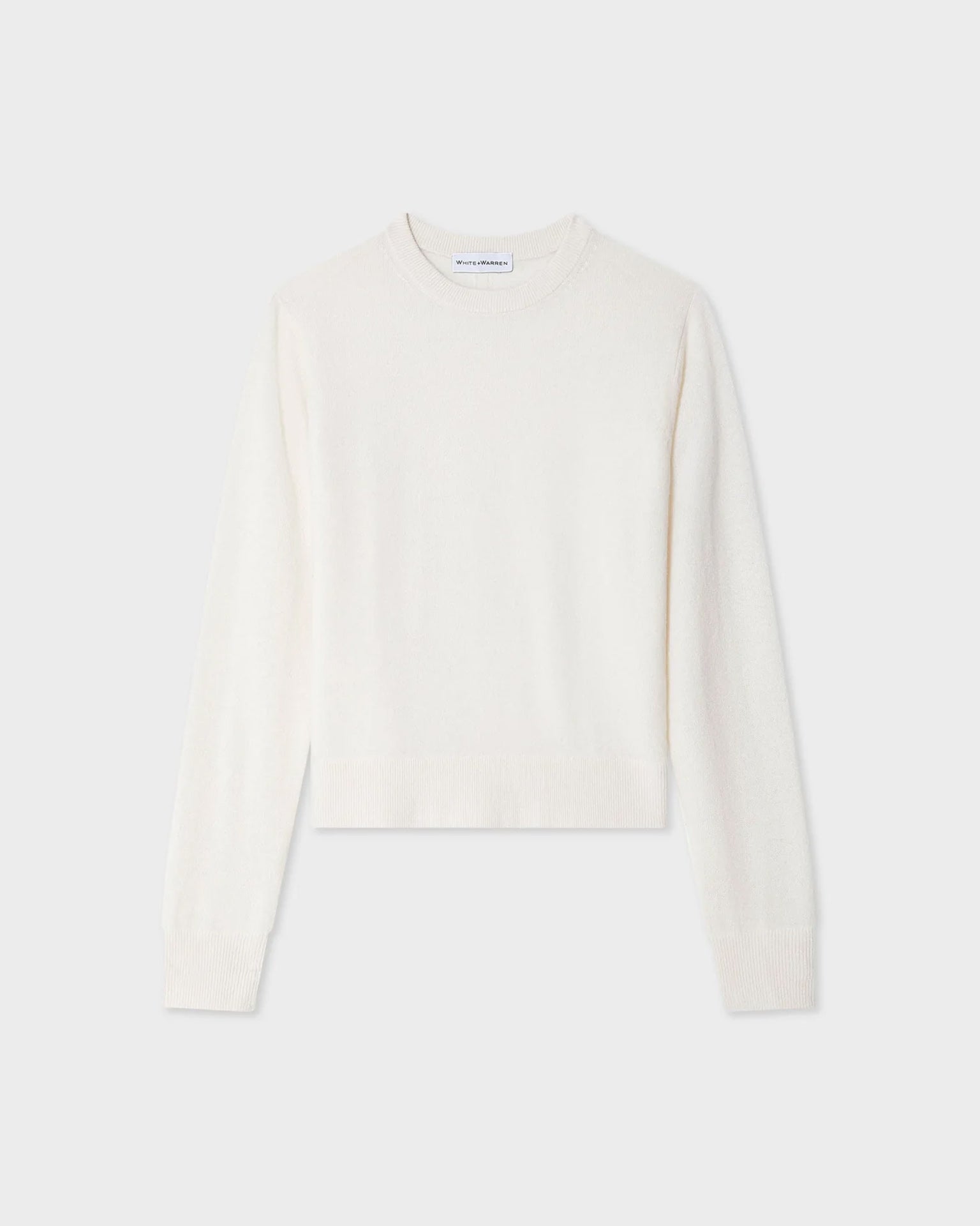 The White & Warren Cashmere Crew in Soft White, a relaxed fit sweater, is shown in solid off-white and displayed flat against a light gray background.