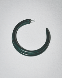 A single C Hoop in Large Hike by B&L, dark green and crescent-shaped with two visible metal posts, rests on a white textured surface—handcrafted from sustainably sourced materials for a distinctive look.