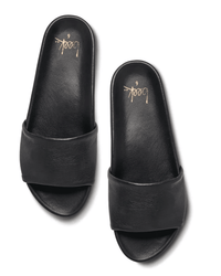 A pair of Gallito in Black leather slides by beek. with wide straps, seen from above on a white background. The molded footbed insoles display the beek. brand name and size 6 in gold lettering.