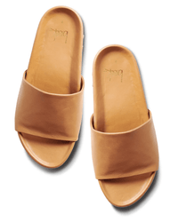 The beek.. Pelican in Honey slides feature tan leather wide straps, open toes, and subtle arch support, shown against a white background.