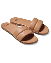 A pair of beek.. Sugarbird in Beach tan slide sandals with cushioned wide single straps and flat memory foam soles, displayed side by side on a white background.