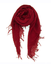 The Chan Luu Cashmere & Silk Scarf in Biking Red, featuring frayed edges, is rolled into a loose swirl and displayed on a white background.