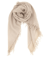 The Chan Luu Cashmere & Silk Scarf in Doeskin features frayed edges and elegant fringed trims, shown loosely rolled and laid flat on a white background.