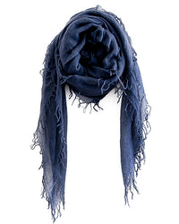 The Chan Luu Cashmere & Silk Scarf in Indigo features frayed edges and long, thin tassels, shown loosely folded against a white background.