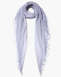 The Chan Luu Cashmere & Silk Scarf in Lilac Hint, with frayed edges on a white background, exudes elegance and charm.