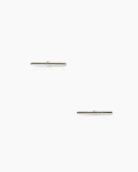 The Chan Luu Silver Bar Stud Earrings, handmade in the USA, feature a minimalist, thin design. Displayed diagonally on a plain white background, these small silver studs combine timeless style with quality craftsmanship.