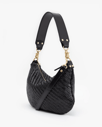 The Clare V. Moyen Messenger in Black Zig Zag is a stylish woven leather crossbody bag with gold hardware, a wide short strap, and a detachable long strap, showcased against a white background.