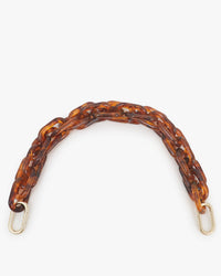 The Clare V. Shortie Strap in Tortoise Acrylic features chunky resin interlocking links and gold-tone clasps, perfect for your bag. Displayed against a white background.