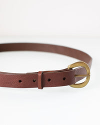 The Depalma Handsewn CL 1 inch Belt in Bark/Brass, made of genuine leather with a brass buckle, is coiled in a circle on a white background.