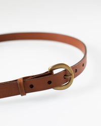 The Depalma Handsewn CL 3/4 inch Belt in Tobacco, with a brass buckle, is displayed coiled on a white background.