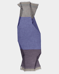 The Épice Check 4 Scarf in Violet is an oversized piece featuring a multicolored houndstooth pattern in blue, brown, and cream, with short fringe edges and wavy, irregular lines.