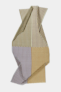The Épice Checks Scarf in Golden features a geometric pattern in olive green, mustard yellow, lavender, and blue on cotton-silk fabric, arranged in vertical sections against a white background.