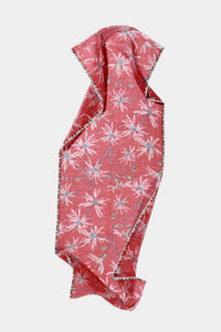 The Meadow Orchids Scarf in Calypso by Épice is a pink floral handwoven scarf with white and light pink patterns, slightly textured fabric, finished edges, and a loose, flowing drape against a plain white background.