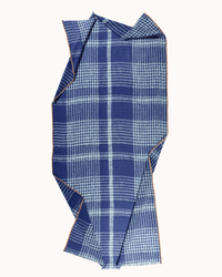 The Épice Tweed Check 1 Scarf in Cobalt displays a blue and white checkered pattern with orange edge stitching, laid flat with visible folds.