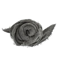 A Grisal Love Cashmere Scarf in Heather Grey X Charcoal, fringed and loosely rolled with ends visible, is displayed on a white background.