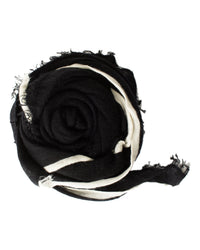 The Grisal Rosa Cashmere Scarf in Black x Milk features a luxurious black knit with frayed edges and a white stripe, shown rolled into a spiral against a white background.