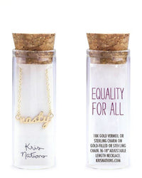Two glass bottles by Kris Nations: one showcases the Nasty Necklace in Gold; the other reads "EQUALITY FOR ALL" and provides details about this adjustable gold necklace and its materials.