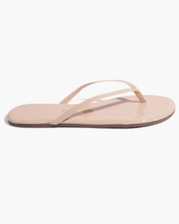 A single Tkees Glosses Flip Flop in rose, featuring thin straps and a flat sole made from supple leather, is shown from the side against a white background.