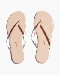 The Tkees Glosses Flip Flop in Rose features a minimalist nude design with thin straps and soft cowhide, displayed on a white background. The insoles display the Tkees brand name.