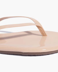 Close-up of the Tkees Glosses Flip Flop in Rose, featuring thin straps and a flat sole made from smooth rose cowhide leather, shown against a white background.