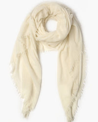 The Chan Luu Cashmere Scarf in White, featuring a soft texture and delicate fringed trim, is arranged in a loose circular shape on a white background.