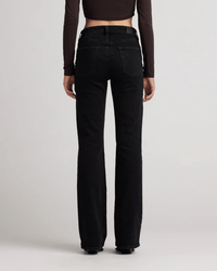 A person wears Edwin's Lark in Ramble mid-rise boot jeans and a long-sleeve crop top, shown from the back against a plain light background.