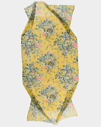 The Fleur 1 Scarf in Yellow by Épice features blue, pink, and green floral motifs hand screen printed on wool. Displayed with gentle folds and textured edges, it's photographed against a plain white background.