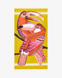 Illustration of two brightly colored toucans with pink, orange, and red feathers on a branch against a yellow background—featured on the Fouta 100 Toucan in Yellow beach towel by Inoui Editions.