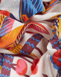 The Scarf 100 Cerise in White by Inoui Editions features abstract patterns in cerise, blue, yellow, and purple on a soft white background. Made from 100% cotton for a vibrant and comfortable finish.