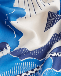 A close-up of the Square 100 Yoga in Blue by Inoui Editions, an oversized cotton-silk blend bandana featuring abstract blue and white prints with wavy lines, geometric shapes, and a small face illustration.