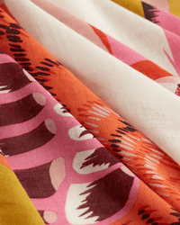 The Inoui Editions Square 130 Toucan in Yellow scarf features a bold, colorful abstract pattern with pink, orange, maroon, yellow, and cream geometric shapes and a visible woven texture for a unique statement piece.