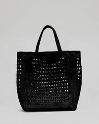 The Annabelle Vertical in Black by Maison N.H Paris is a handmade rectangular raffia tote with two short handles and an open, airy weave, crafted in Madagascar and displayed on a plain light grey background.
