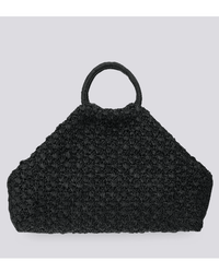 The Clementine Bag in Black by Maison N.H Paris is a handmade, textured woven tote from Madagascar with a wide trapezoidal shape and rounded handle, shown against a plain light grey background.