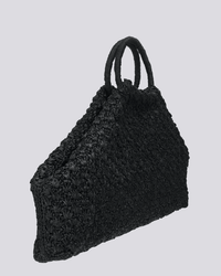 The Clementine Bag in Black by Maison N.H Paris is a handmade woven tote from Madagascar with a triangular shape and two round handles, shown against a plain light gray background.